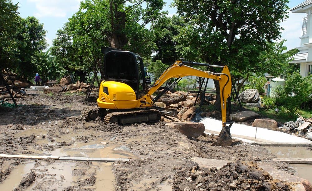 Concrete and site work in progress next to a home