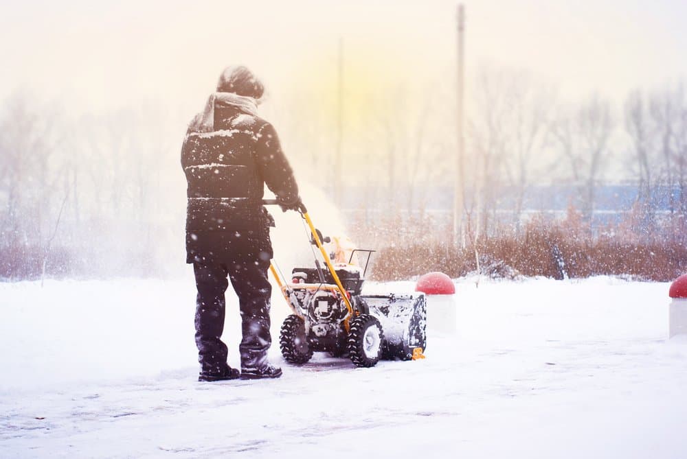 Clearing snow with a snow blower in winter conditions